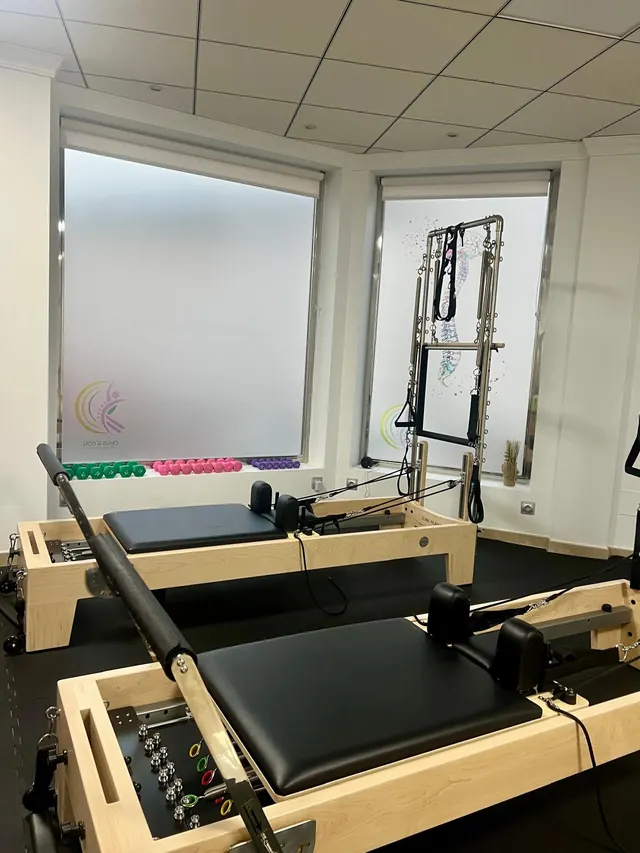 Sala de Pilates Reformer de Chus & Cou con varias máquinas Reformer y una torre